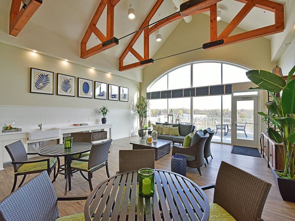 A modern lounge area with high ceilings, large windows, and contemporary furniture.