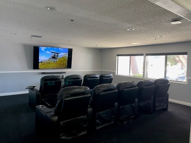 A cozy home theater setup with multiple recliner chairs and a large screen.