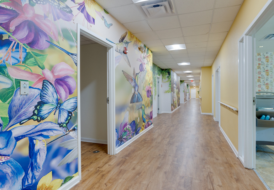 A vibrant hallway with colorful murals featuring butterflies and artistic designs on the walls.