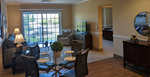 A bright and modern living space featuring a dining table, comfortable seating, and large windows that bring in natural light.