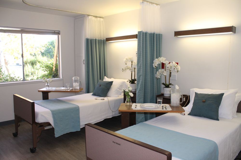 A well-organized hospital room with two beds and decorative elements.