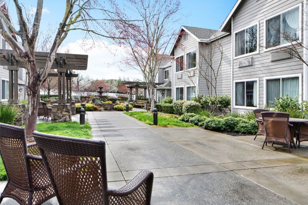 A peaceful courtyard with a walkway and benches surrounded by residential buildings.