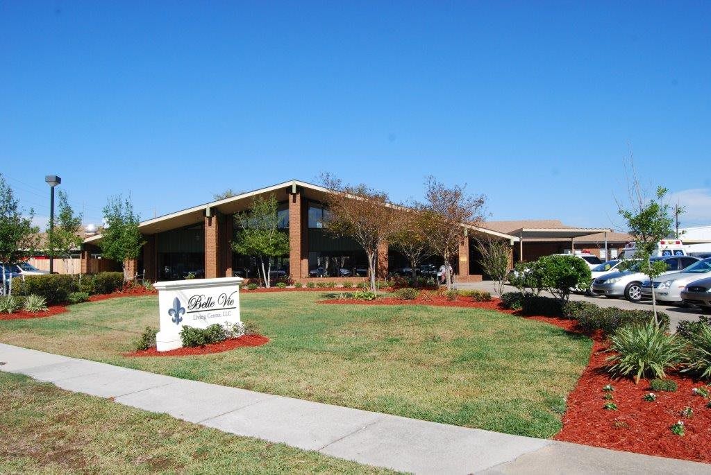 A sunny day outside a school building with well-maintained landscaping.
