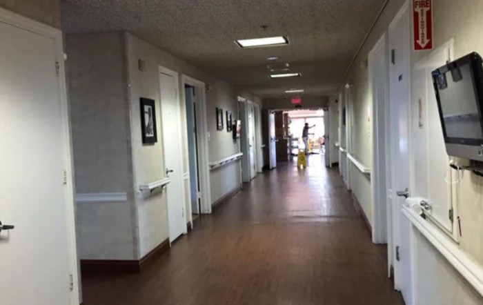 A well-lit hallway inside a building, possibly a hospital or healthcare facility.