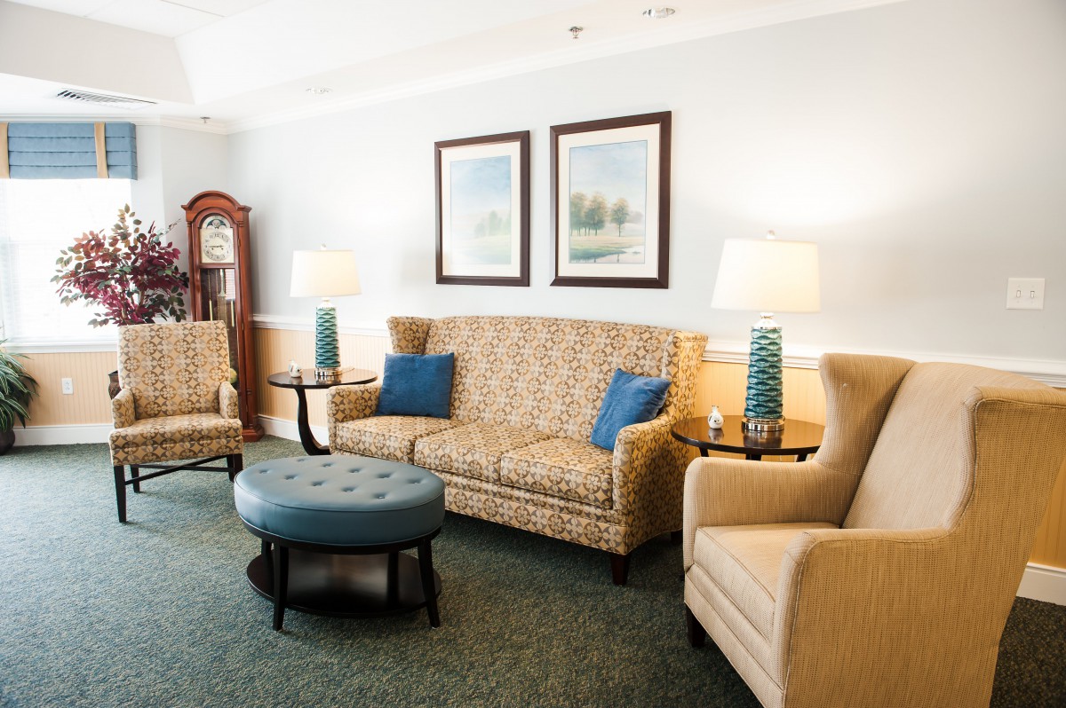 A cozy living room setup with a sofa, two armchairs, coffee table, and decorative lamps.