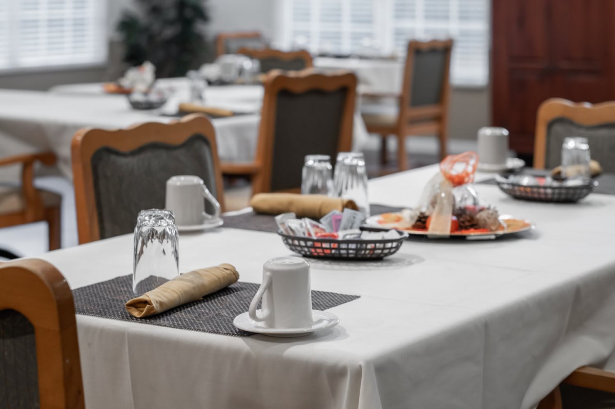 A neatly set dining table in a restaurant, prepared for breakfast service.