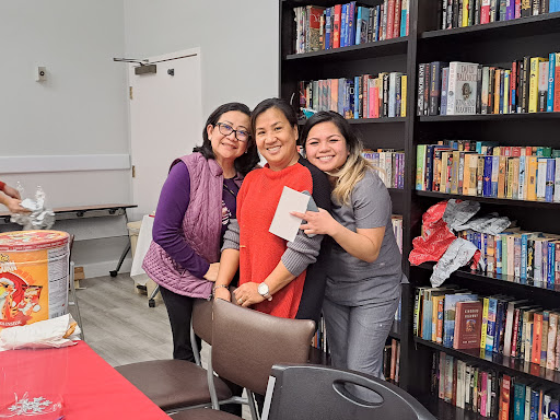 A joyful moment shared among friends at a gathering surrounded by books.