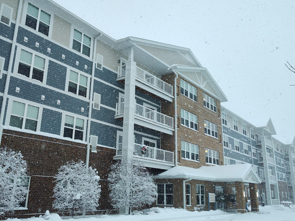 A snow-covered apartment building on a cold winter day.