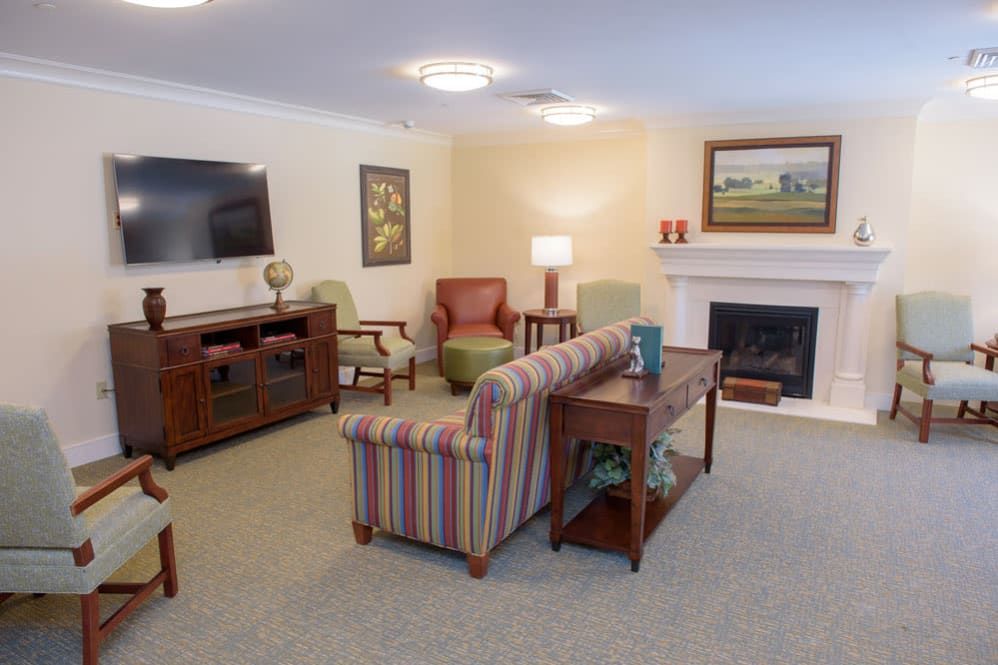 Cozy living room with a sofa, armchairs, and a fireplace.