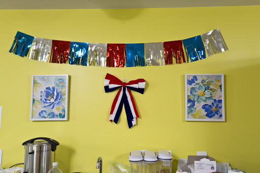 A vibrant display of festive decorations, featuring a colorful bunting and a striped ribbon on a cheerful yellow wall.