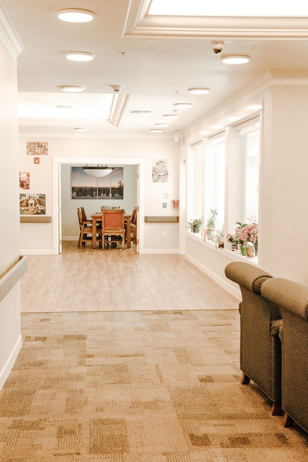 A bright, inviting hallway leading to a dining area with tables and chairs.