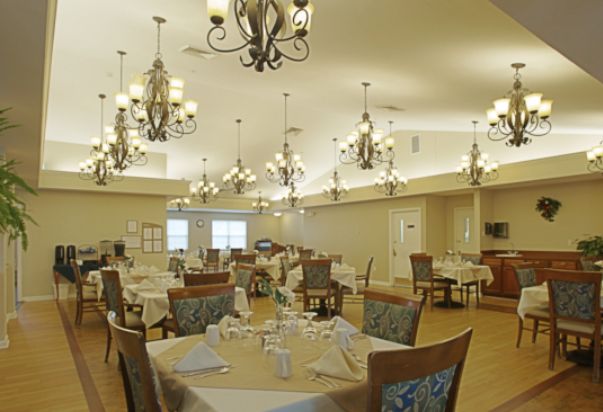 An elegant dining room with chandeliers and neatly arranged tables and chairs.