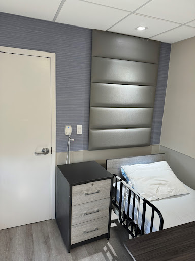 A well-designed hospital room featuring a bed and modern furnishings.