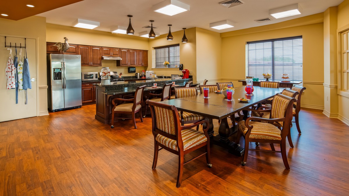 A spacious kitchen and dining area with wooden flooring and elegant furniture.
