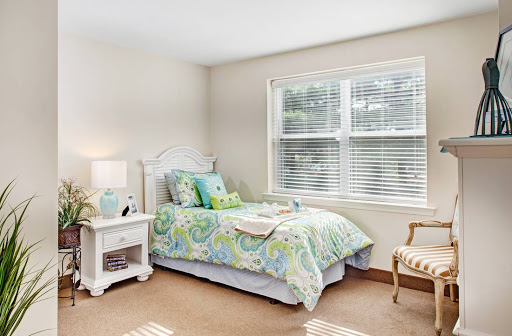 A serene and cozy bedroom featuring soft bedding and natural light.