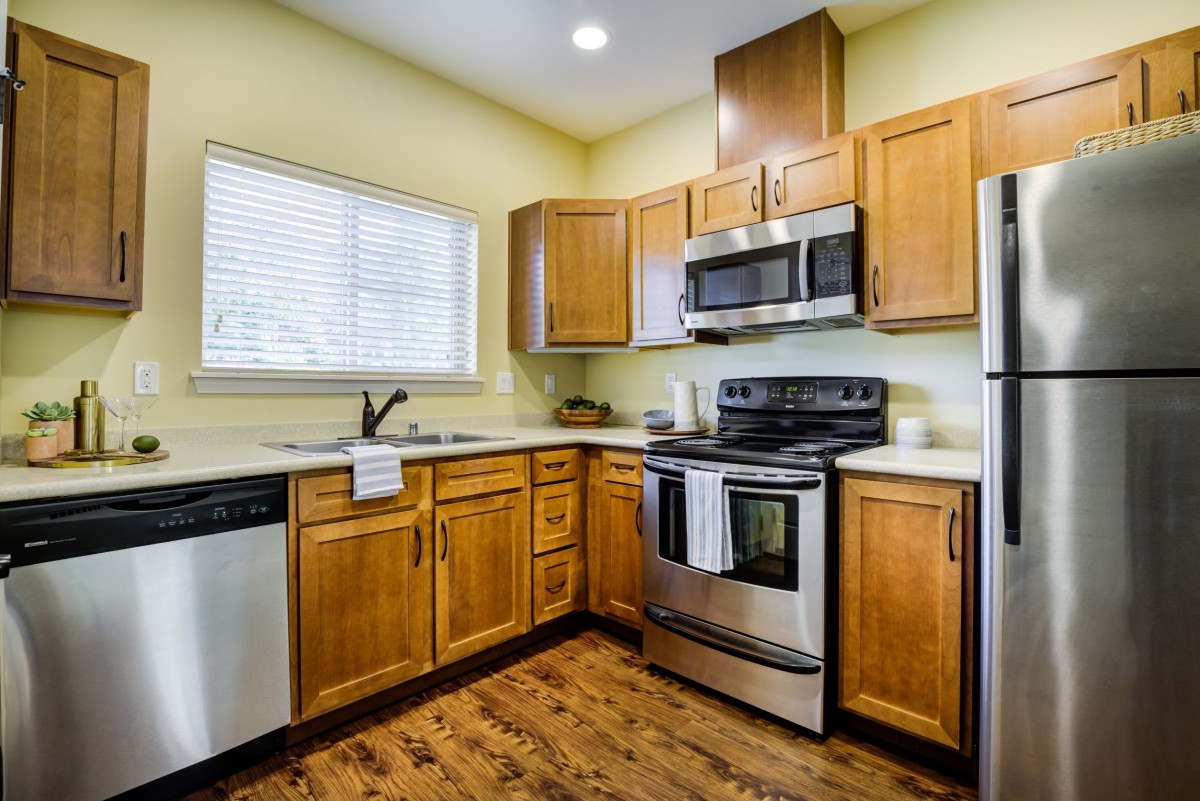 A modern kitchen with wooden cabinets and stainless steel appliances.