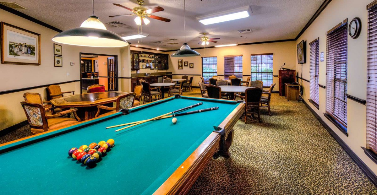 A cozy recreational room featuring a pool table, bar area, and seating for relaxation.