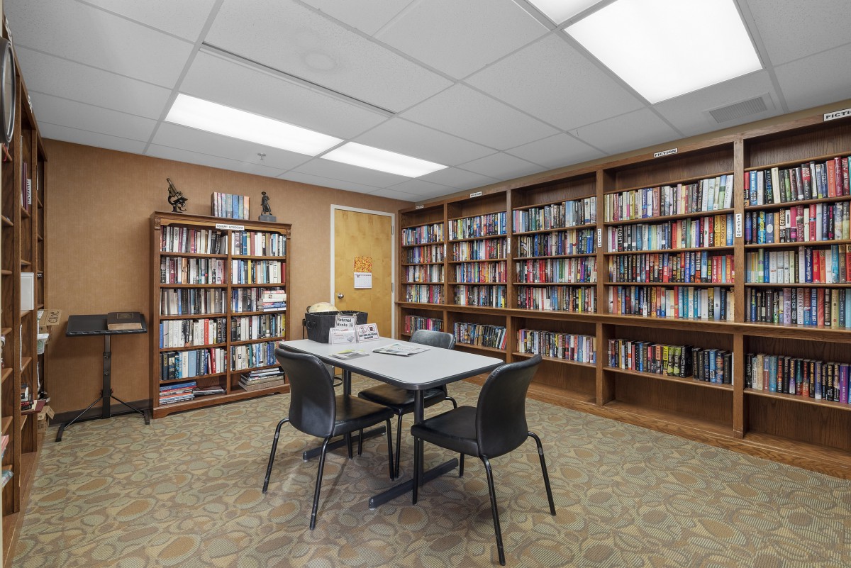 A quiet study area in a library with bookshelves, a table, and chairs.