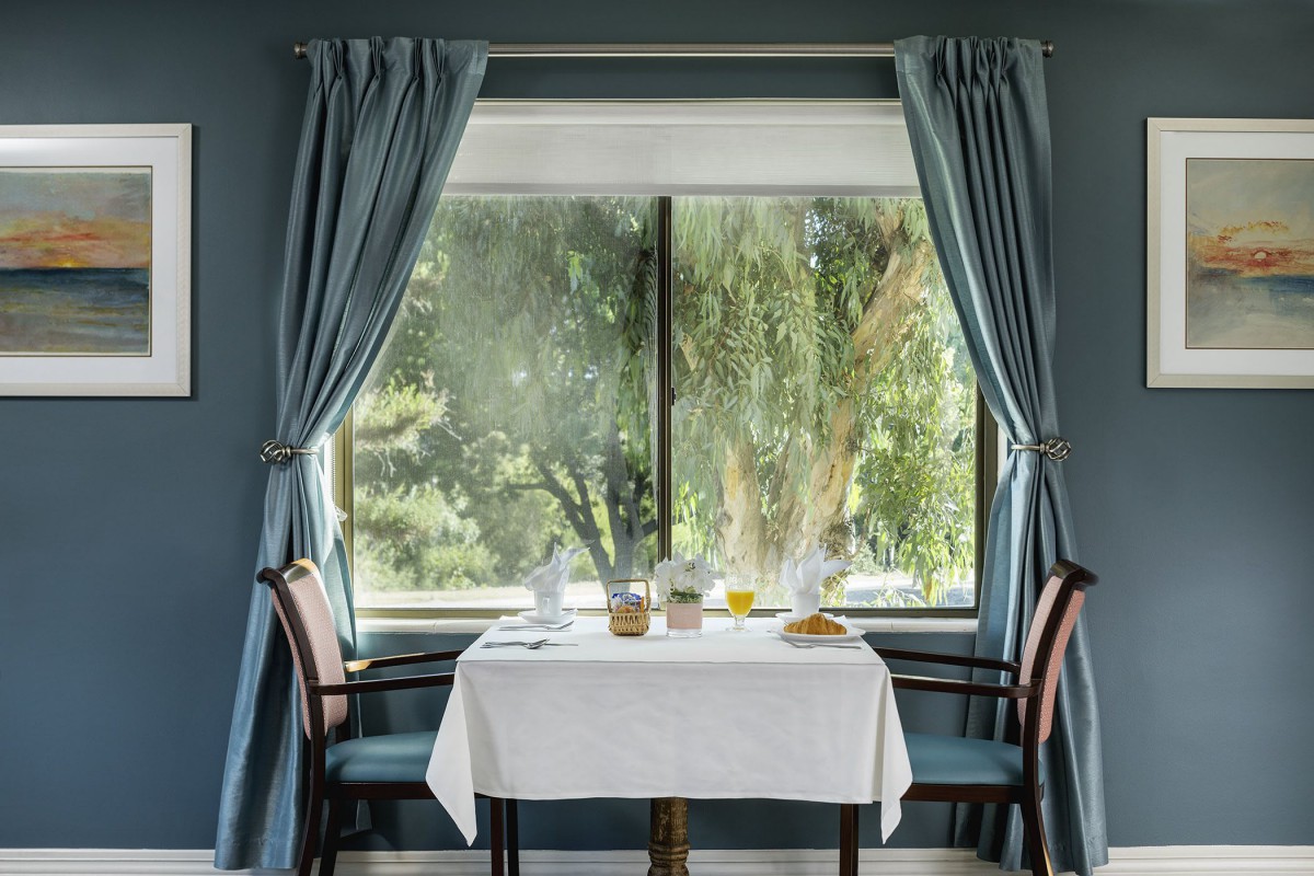 A cozy dining setup by a large window with a scenic outdoor view.
