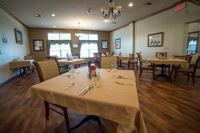 An empty restaurant dining room with tables set for service.