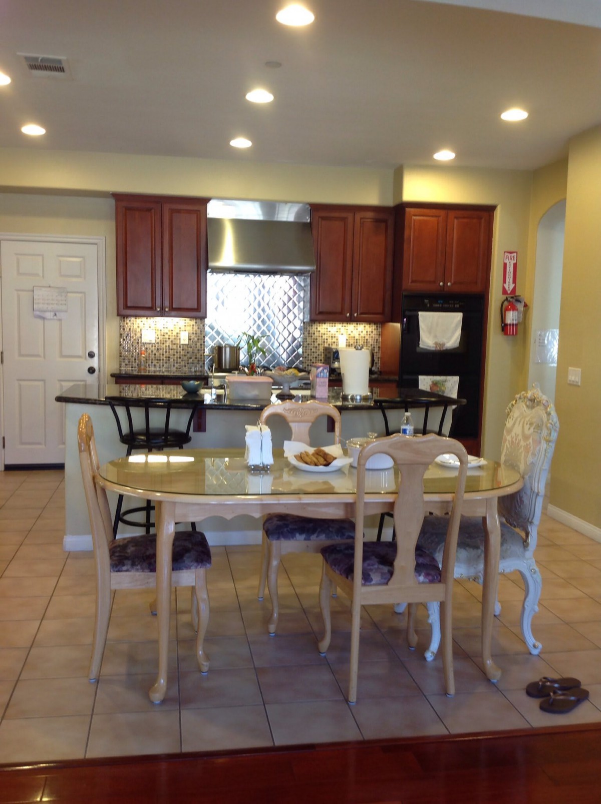 A cozy kitchen and dining area with a table and chairs, featuring wooden cabinets and modern appliances.