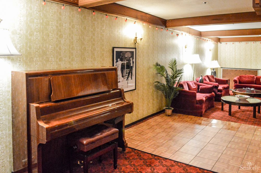 A cozy lounge with a vintage piano and comfortable seating arrangement.