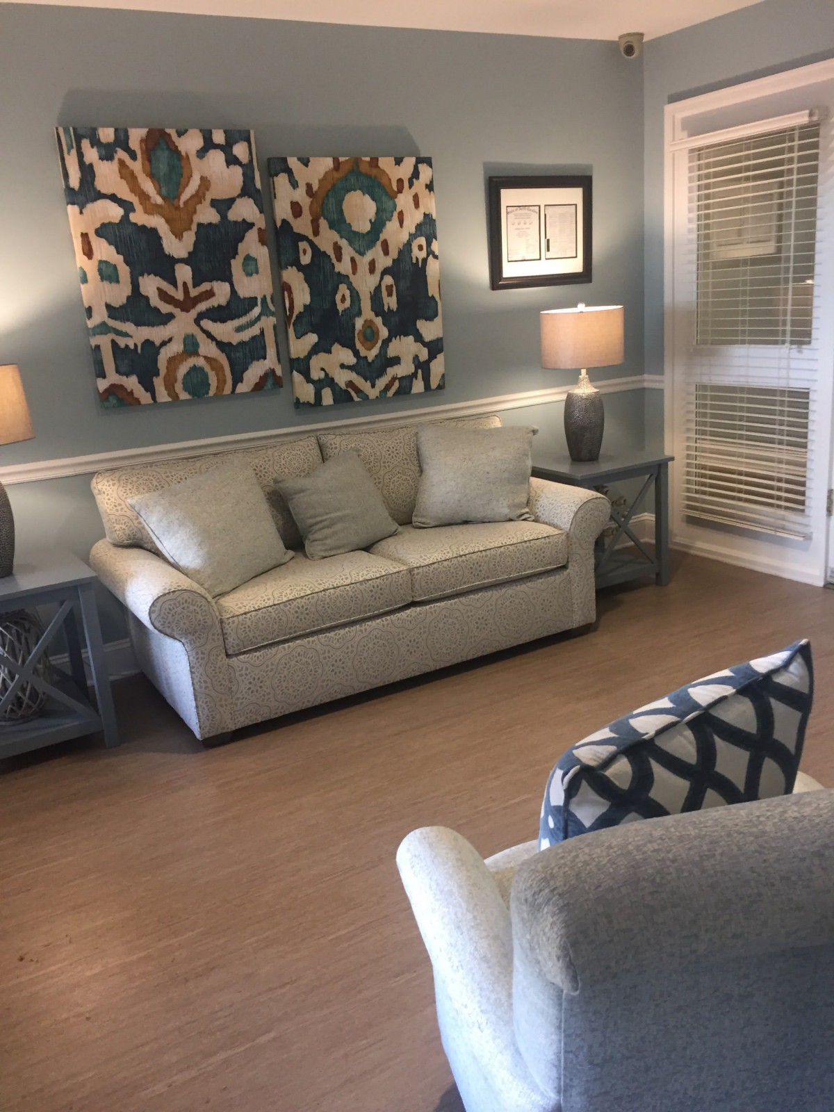 A cozy living room featuring a beige sofa, modern lamps, and decorative artwork on the walls.