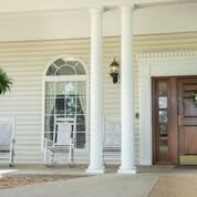 A welcoming front porch with white columns and rocking chairs.