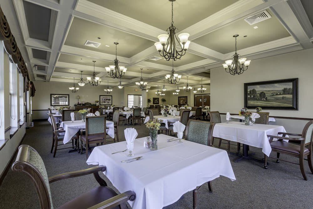 An elegant dining room with white tablecloths and chandeliers.