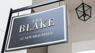 A sign for 'The Blake at New Braunfels' displayed on the side of a building.