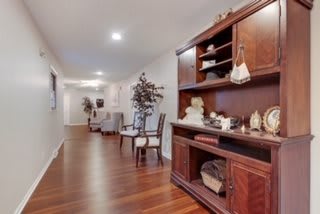 A well-decorated hallway with wooden flooring and elegant furniture pieces.