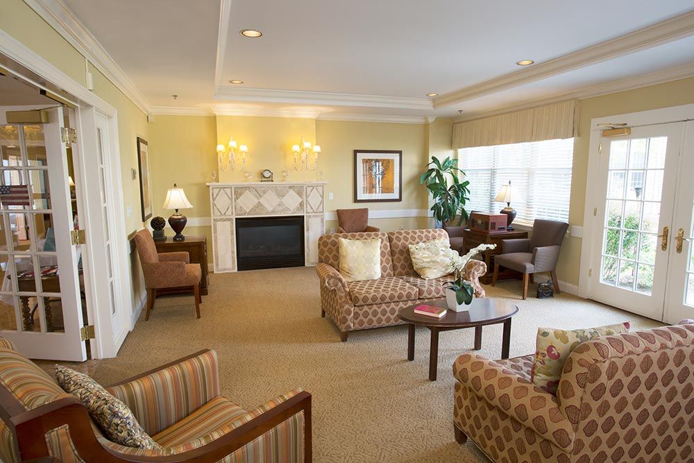 A cozy and elegantly decorated living room with a fireplace, sofas, and warm lighting.