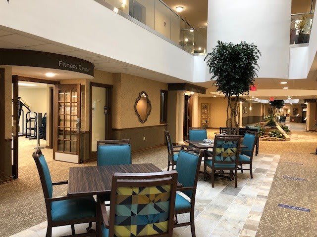 A spacious lobby area with tables and chairs, featuring modern design elements and lighting.