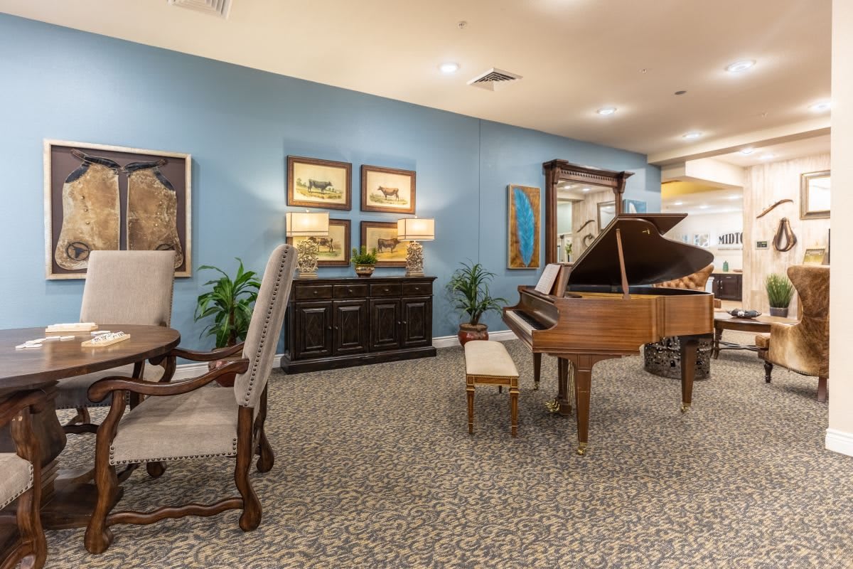 A stylish living room featuring a grand piano and elegant decor.