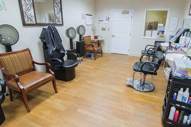 An interior view of a salon with barber chairs, mirrors, and a waiting area.