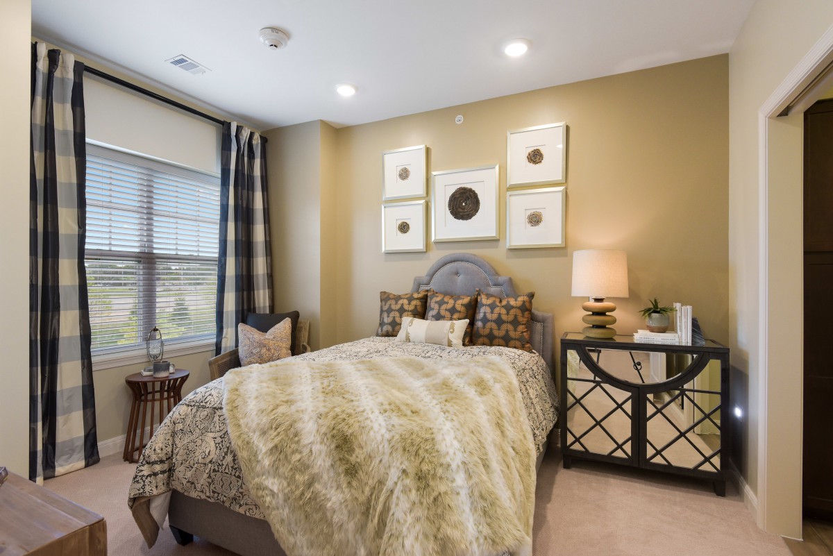 A modern bedroom with stylish decor and soft lighting.