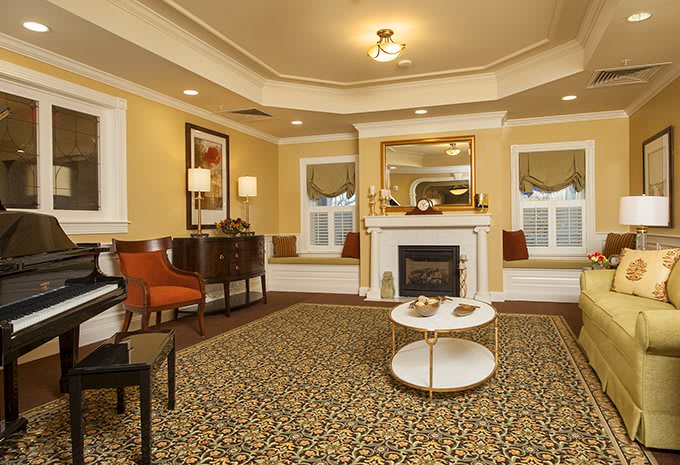 A cozy living room with a central fireplace, elegant furniture, and warm lighting.