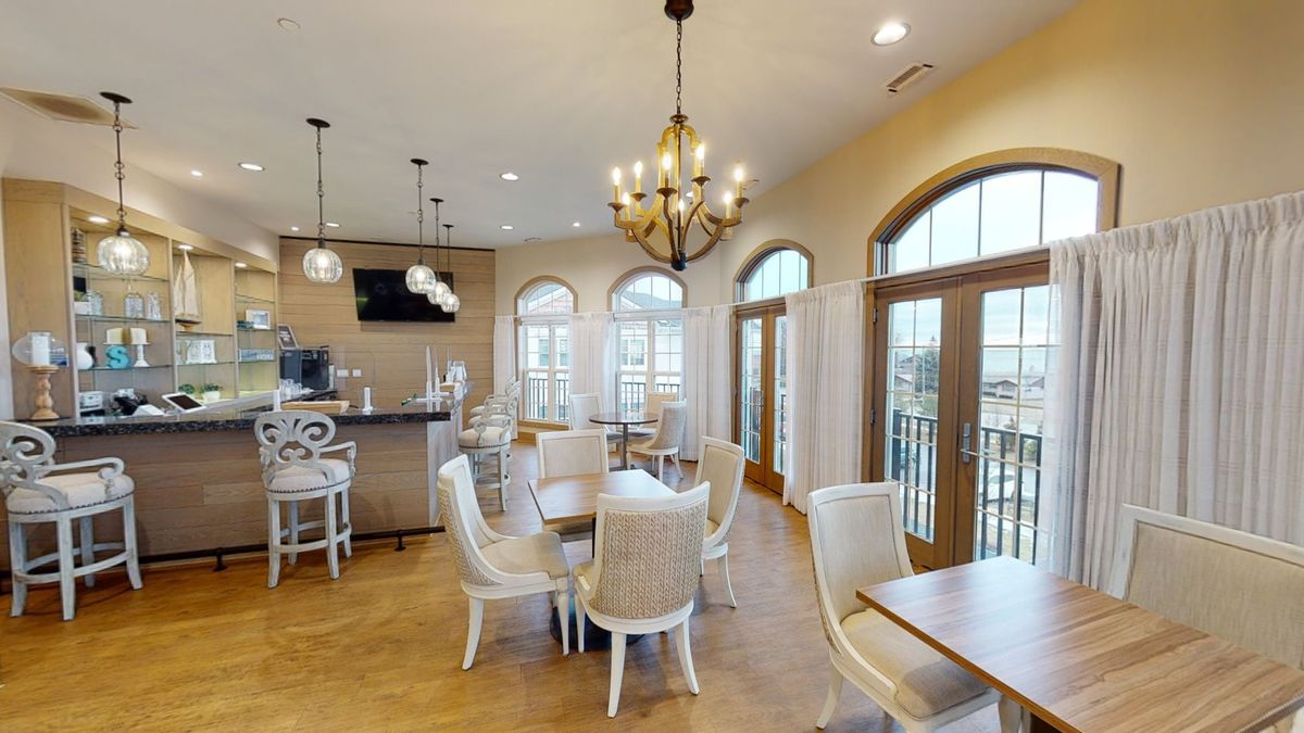 A modern dining area with elegant furniture and large windows offering a scenic view.