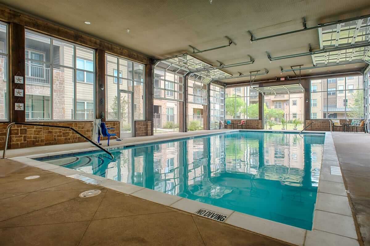 A spacious indoor swimming pool with large windows and modern architecture.