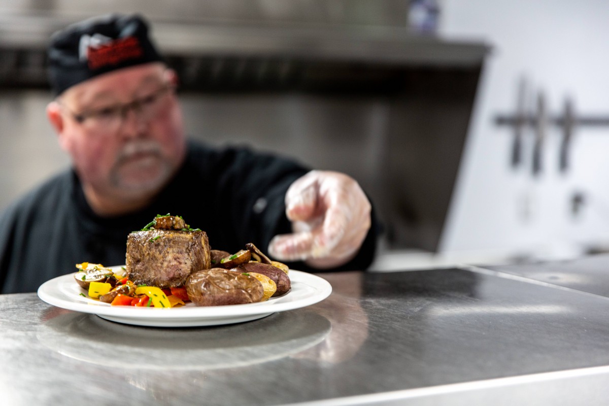 A chef carefully plating a dish in a professional kitchen.