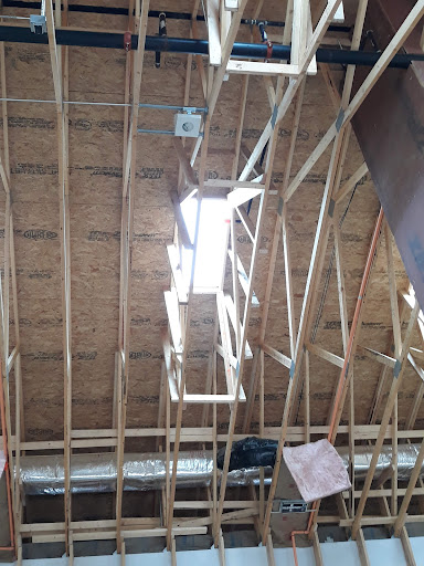 View of the interior roof structure highlighting wooden beams and natural light.