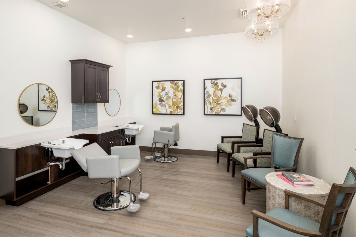 Modern hair salon interior with chairs, hair dryers, and decorative artwork.