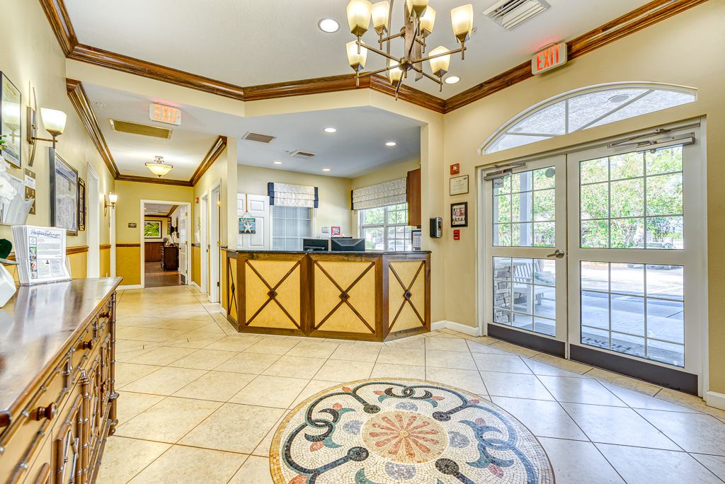 Spacious lobby with a reception desk and elegant chandelier.