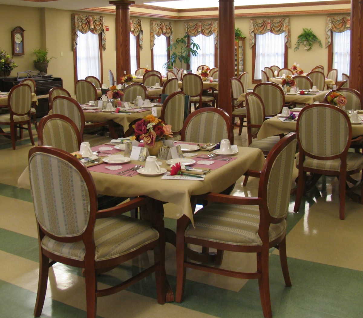 An elegantly set dining room with tables and chairs arranged for guests.