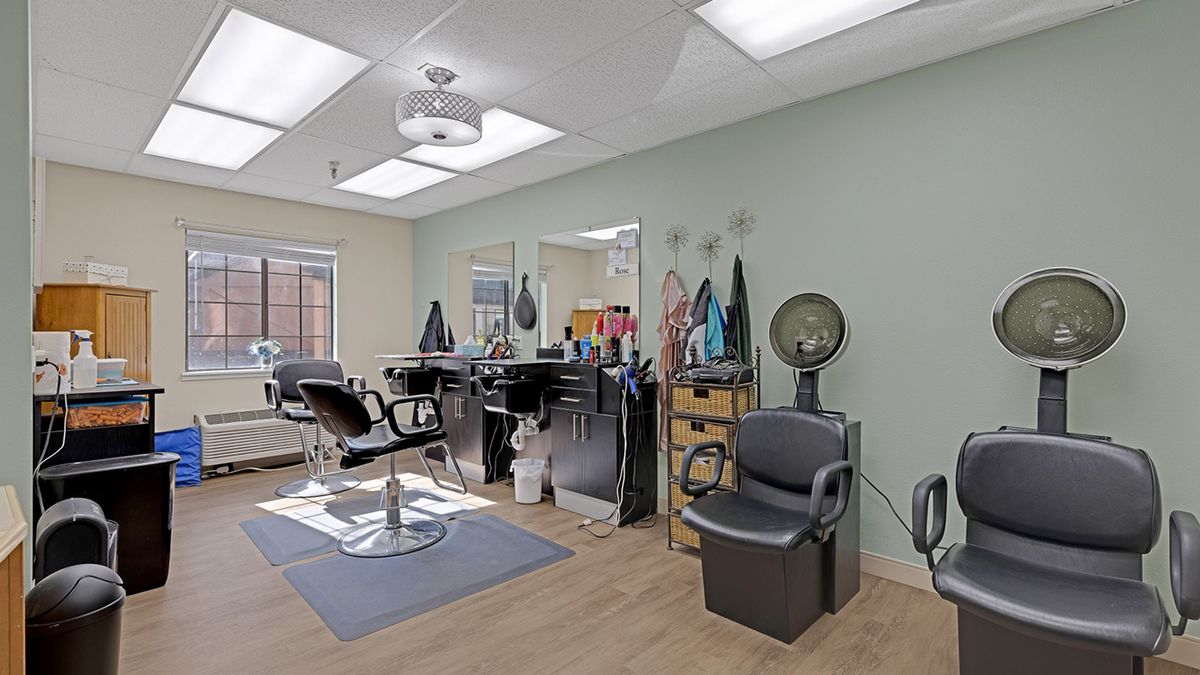 A clean and well-lit hair salon interior with multiple styling stations and chairs.
