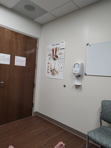 A view of a doctor's office waiting area with medical posters and hygiene supplies.