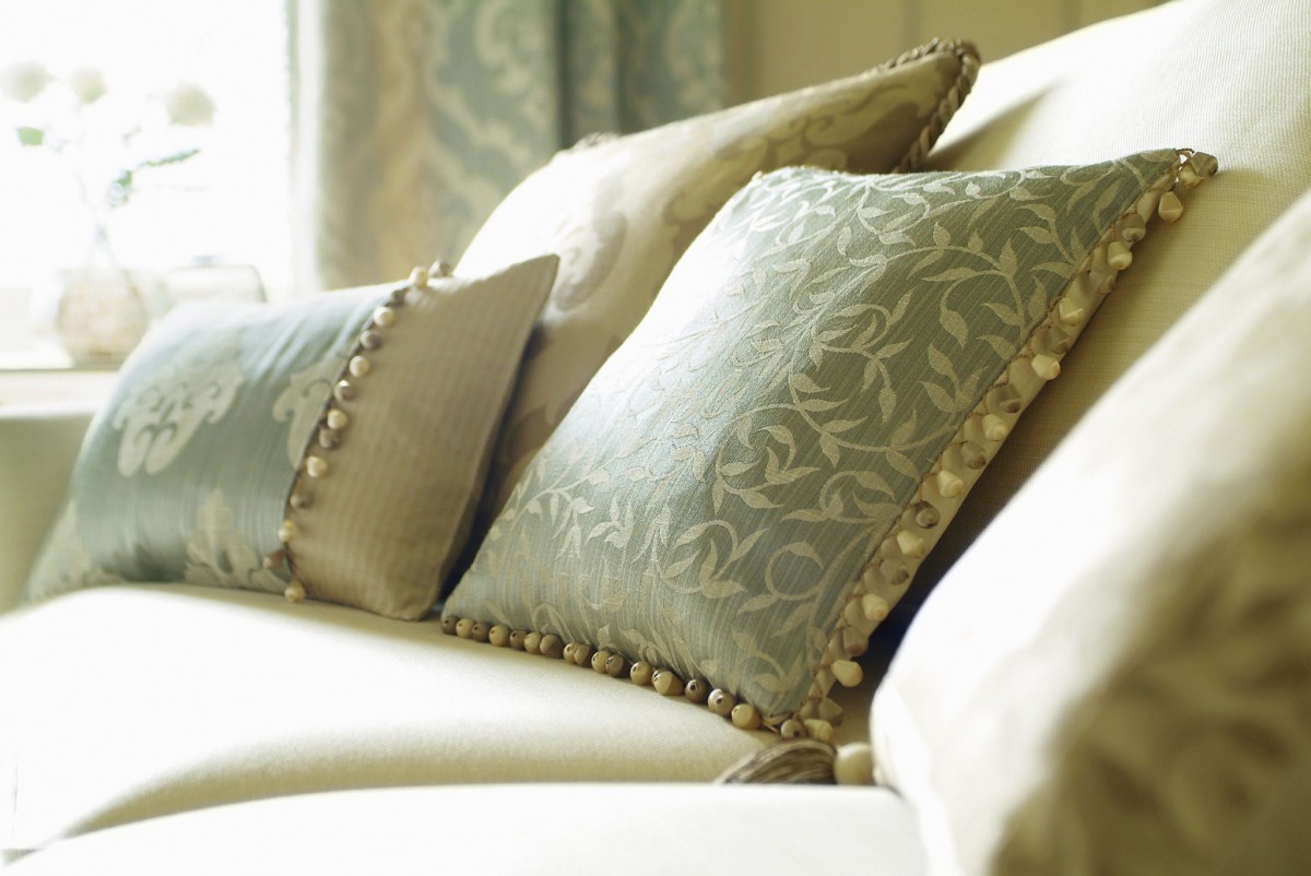 Elegant decorative pillows with intricate patterns displayed on a sofa.