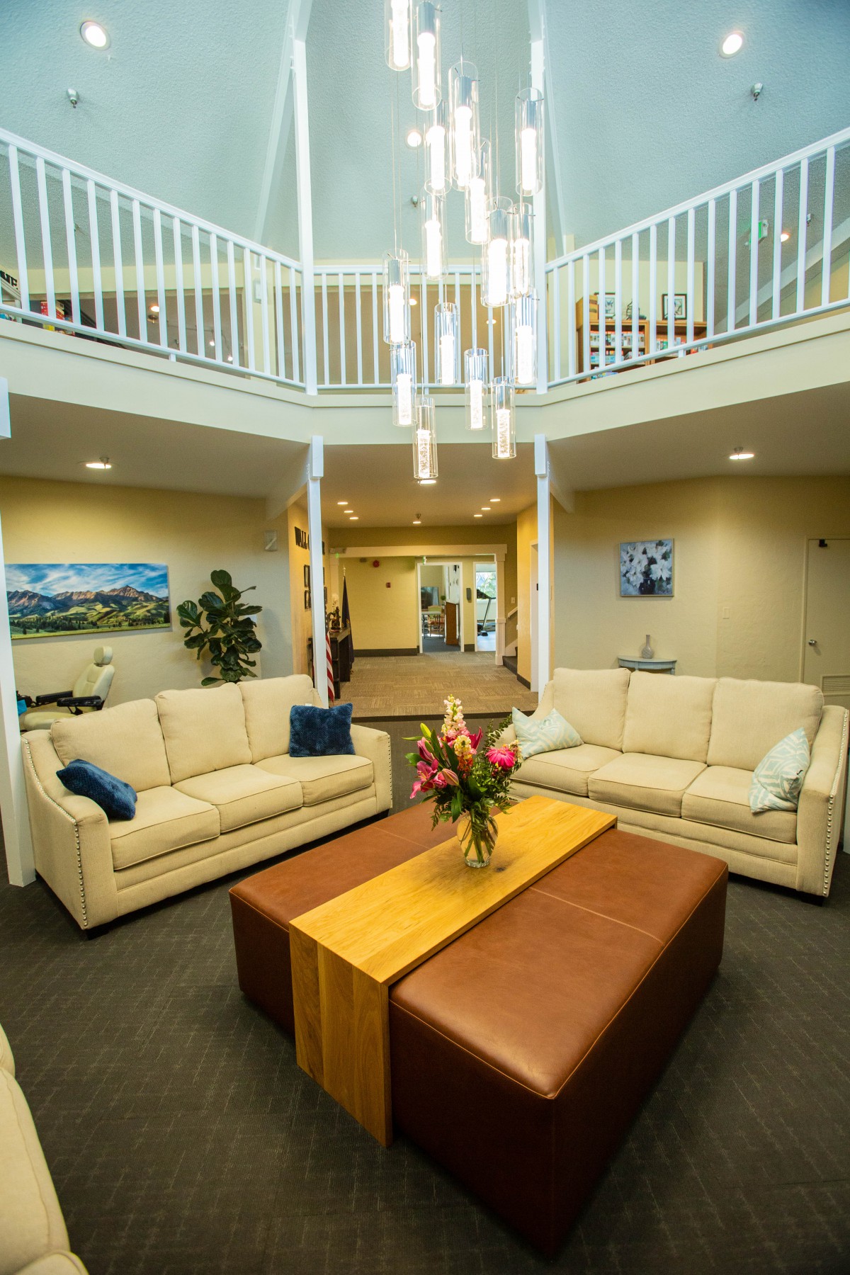 A stylish living room with modern furniture and a central chandelier.
