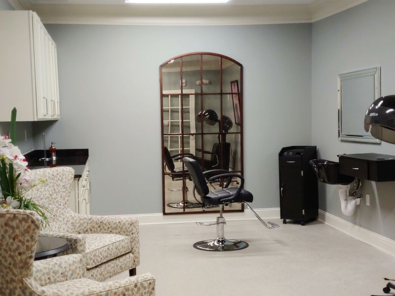 A modern hair salon interior with a styling chair and mirror.