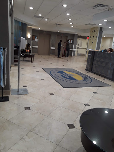 A modern hotel lobby featuring a reception area and elegant flooring.